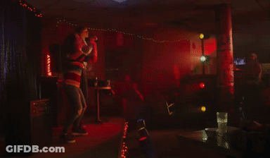 Man And Woman Singing Into Microphones GIF