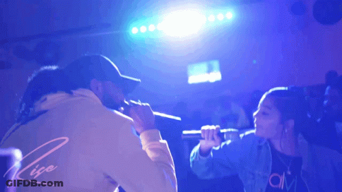 Man And Woman Singing Into Microphones Rise GIF