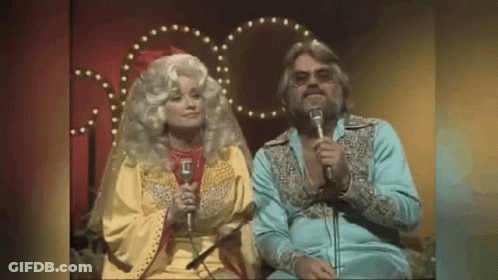 Man And Woman Singing Into Microphones GIF