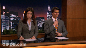 Man And Woman Sitting At Desk In Front Of City At Night GIF