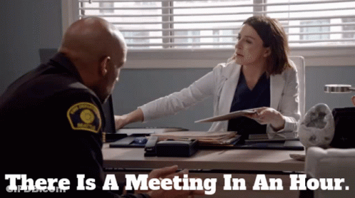Man And Woman Sitting At Desk There Is A Meeting In An Hour GIF