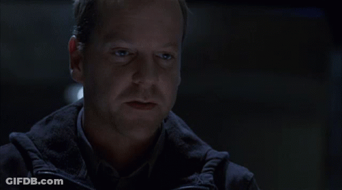 Man And Woman Sitting At Table In Dark Room Talking GIF