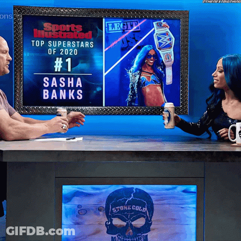 Man And Woman Sitting At Table Under Sasha Banks Picture GIF