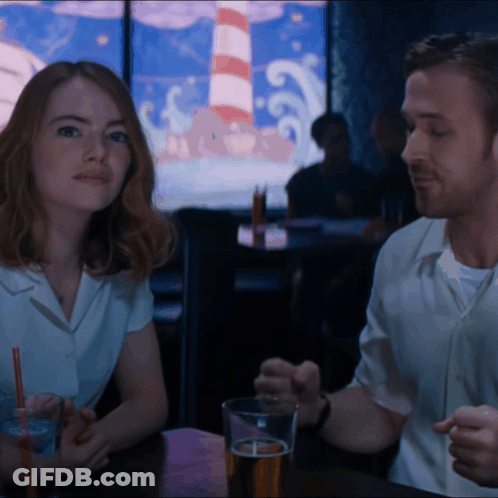 Man And Woman Sitting At Table With Beer GIF