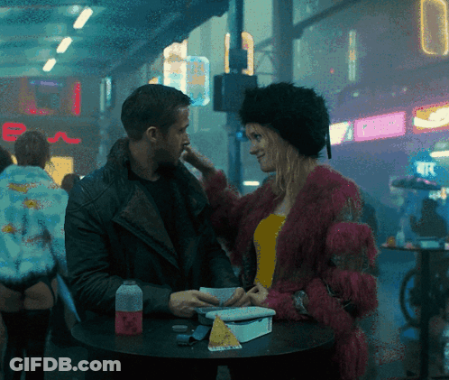 Man And Woman Sitting At Table With E Sign GIF