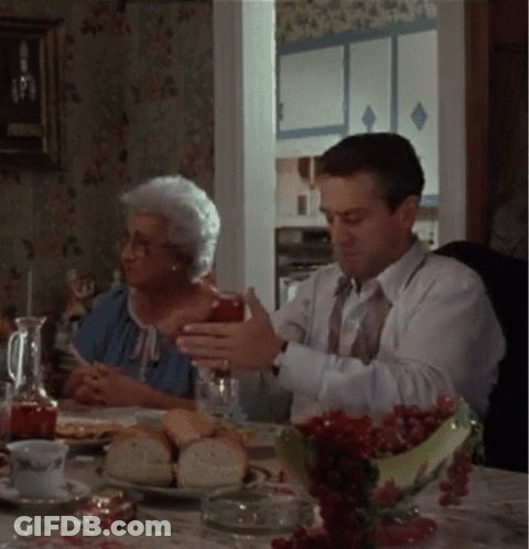 Man And Woman Sitting At Table With Food And Drinks GIF