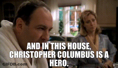 Man And Woman Sitting At Table With House And Columbus Text GIF
