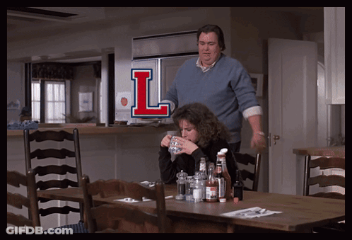 Man And Woman Sitting At Table With Letter L GIF