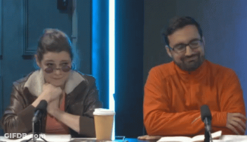 Man And Woman Sitting At Table With Microphones GIF