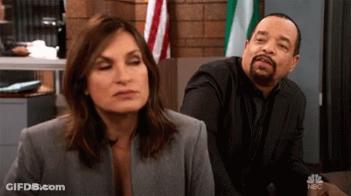 Man And Woman Sitting At Table With NBC GIF
