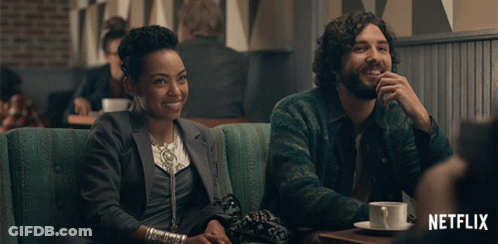 Man And Woman Sitting At Table With Netflix Logo GIF