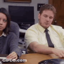 Man And Woman Sitting At Table With Phone GIF