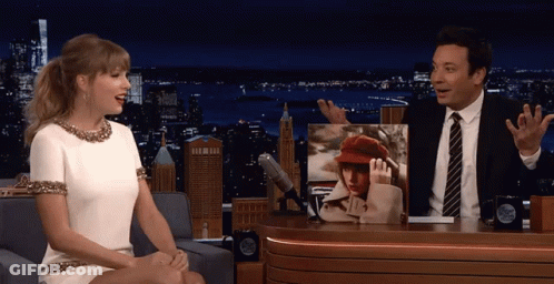 Man And Woman Sitting At Table With Taylor Swift Picture GIF