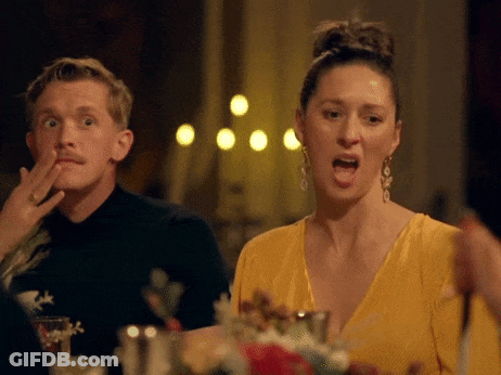 Man And Woman Sitting At Table Woman In Yellow Dress And Earrings GIF