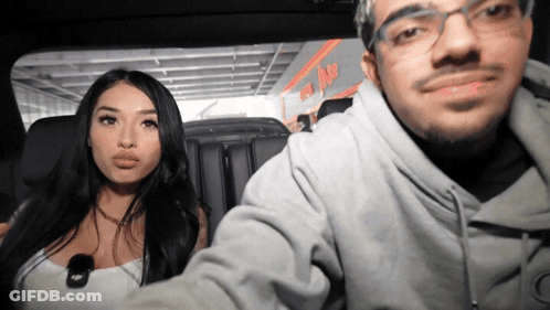 Man And Woman Sitting In Car In Front Of ABC Sign GIF