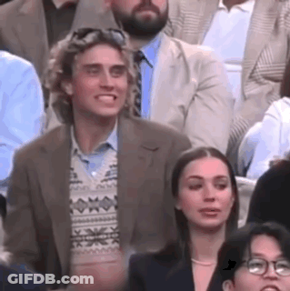Man And Woman Sitting In Crowd GIF