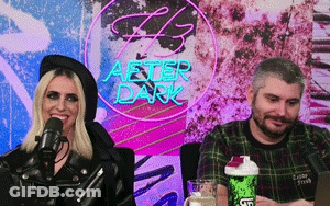 Man And Woman Sitting In Front Of After Dark Neon Sign GIF