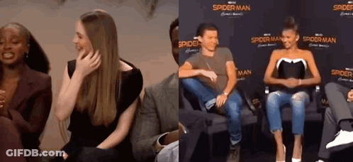 Man And Woman Sitting In Front Of Spider-Man Sign GIF