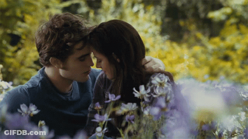 Man And Woman Sitting In Purple Flowers GIF