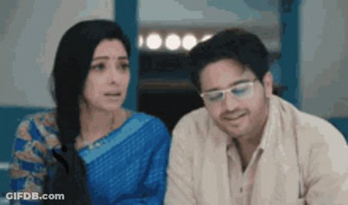 Man And Woman Sitting Next To Each Other Looking GIF