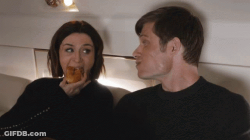 Man And Woman Sitting Next To Each Other Woman Eating GIF