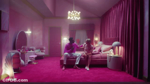 Man And Woman Sitting On Bed In Pink Room GIF
