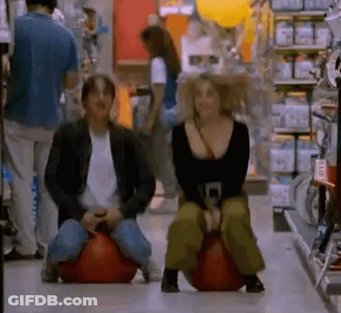Man And Woman Sitting On Bouncy Balls In Grocery Store GIF