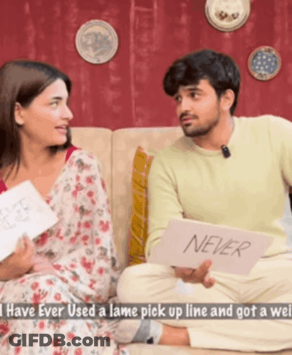 Man And Woman Sitting On Couch Holding Never Card GIF