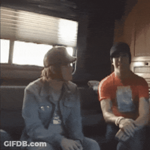 Man And Woman Sitting On Couch In Dark Room GIF
