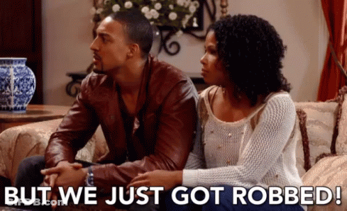 Man And Woman Sitting On Couch Saying But We Just Got Robbed GIF