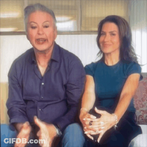Man And Woman Sitting On Couch With Hands Folded GIF