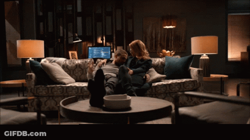 Man And Woman Sitting On Couch GIF