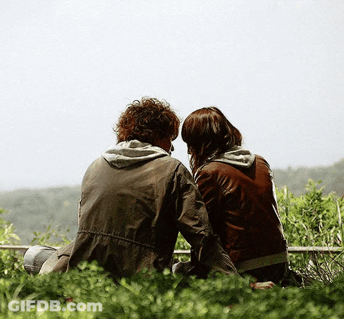 Man And Woman Sitting On Ledge Looking At Sky GIF