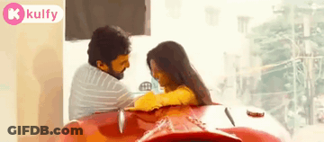 Man And Woman Sitting On Red Car GIF