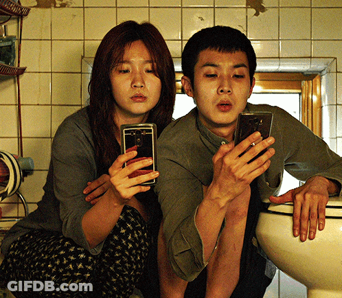 Man And Woman Sitting On Toilet Using Phones GIF