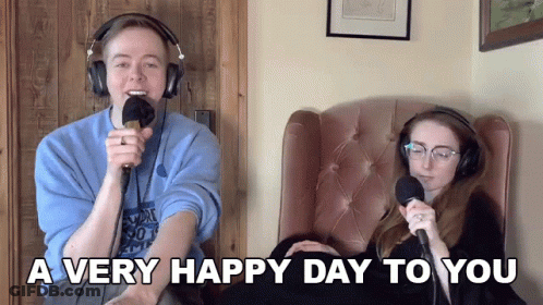 Man And Woman Sitting With Microphones Saying A Very Happy Day To You GIF