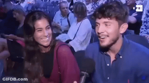 Man And Woman Smiling In Crowd GIF