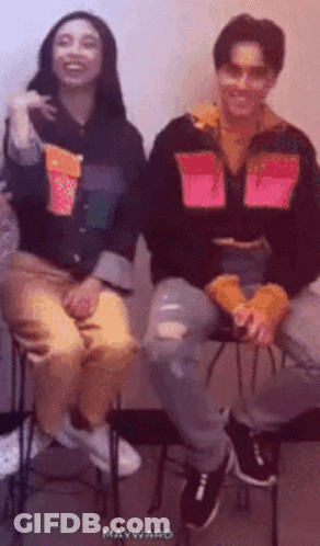 Man And Woman Smiling On Stools GIF
