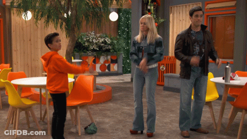 Man And Woman Standing Beside Orange Chairs GIF