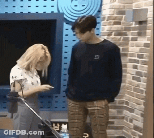 Man And Woman Standing By Brick Wall GIF