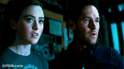 Man And Woman Standing In Dark Room Looking At Something GIF