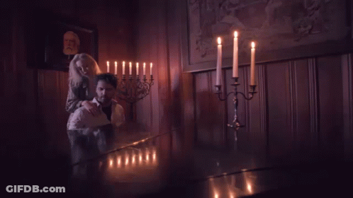 Man And Woman Standing In Dark Room With Candles GIF