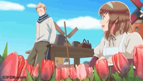Man And Woman Standing In Field Of Flowers GIF