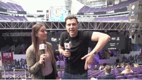 Man And Woman Standing In Front Of Apex Stadium GIF