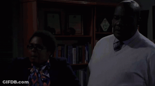 Man And Woman Standing In Front Of Bookshelf GIF