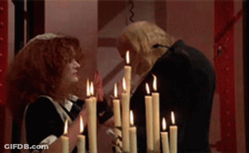 Man And Woman Standing In Front Of Candles GIF