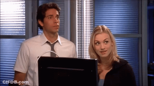 Man And Woman Standing In Front Of Computer Monitor GIF