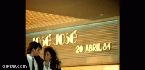 Man And Woman Standing In Front Of Jose Jose GIF