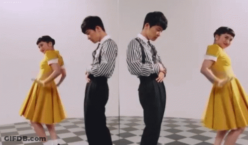 Man And Woman Standing In Front Of Mirror GIF