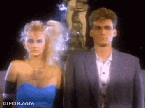 Man And Woman Standing In Front Of Statue GIF